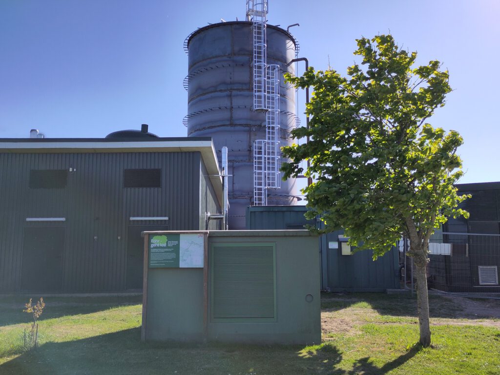Gebäude der Heizzentrale mit neuem Wärmespeicher im Hintergrund.